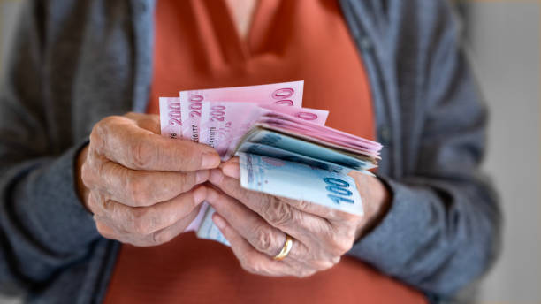 istock Old woman counting Turkish lira banknotes 2174331593