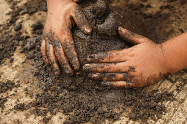istock small child's hands playing with sand and mud. child playing outdoors with mud 2174331747
