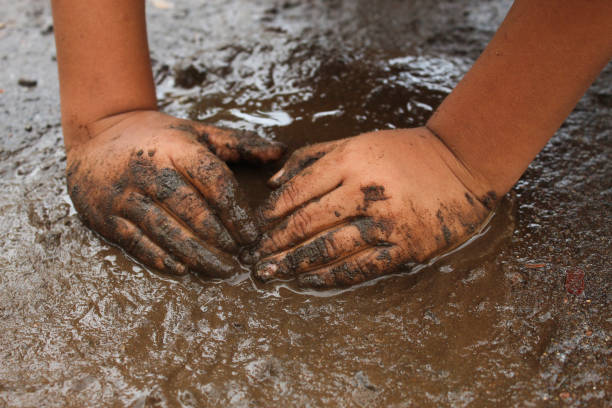 istock small child's hands playing with sand and mud. child playing outdoors with mud 2174331823