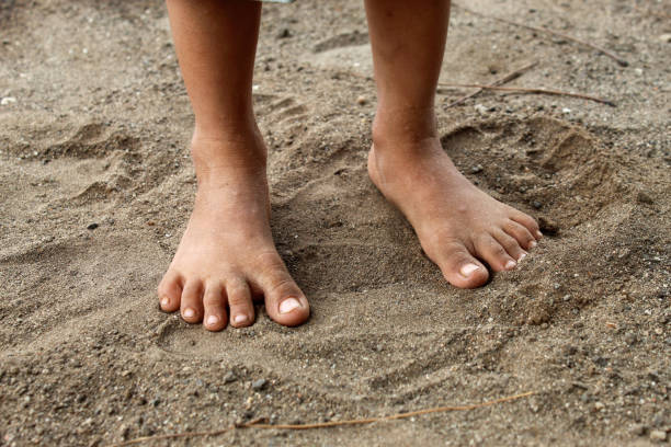 bare feet of a child on the sand