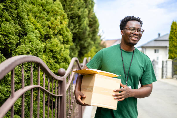 istock Smiling deliveryman carrying packages and parcels. 2174334012