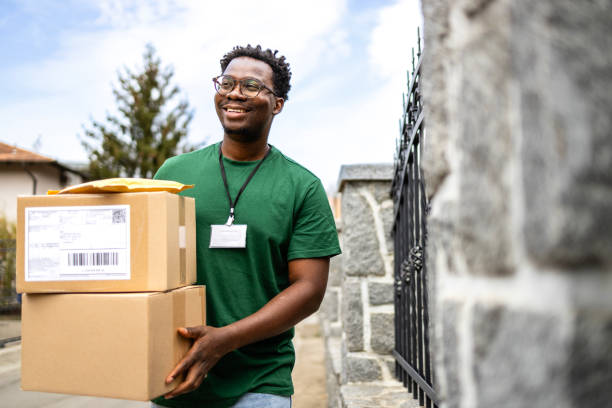 istock Happy postal worker delivering packages and shipment to recipient address. 2174334053