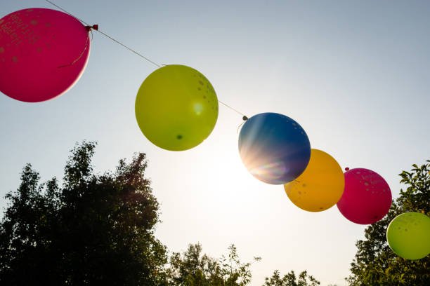 Balloons hang on strings for a children's birthday party in the backyard