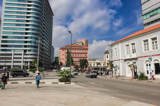 Luanda, Angola - May 17, 2024: The lively intersection in Luanda features modern architecture alongside historical structures with pedestrians vehicles and bright skies enriching the urban atmosphere.