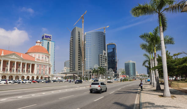 Luanda, Angola - May 17, 2024: A wide avenue in Luanda Angola features a blend of historic and contemporary buildings under construction bustling with traffic and palm trees lining the street.