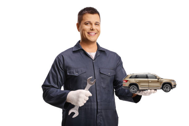 istock Auto mechanic holding a lug wrench and a model car 2174338446