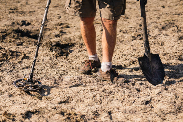 istock A man with a metal detector looking for antique valuables in the ground. 2174338719
