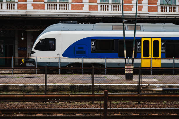 istock Blue and white passenger train at railway station platform 2174341744