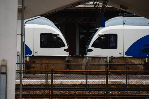 istock Blue and white passenger train at railway station platform 2174341751