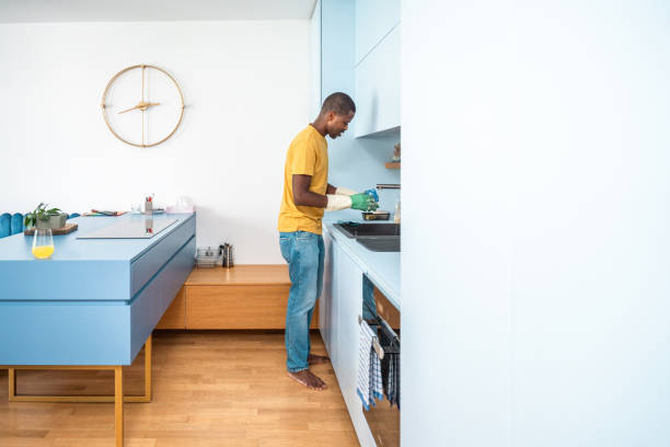 istock Diligent Black Man Engaged in Dishwashing in Modern Kitchen 2174349285