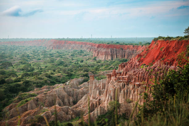 Stunning view of the red cliffs and unique rock formations in Angola's lush landscape under the expansive sky