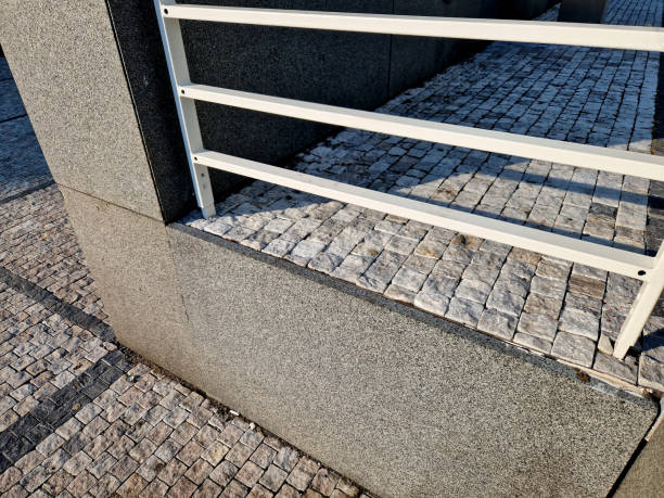 istock bridge railing with vertical fence posts anchored into the ground with four concrete screws. the railing is fixed from the side of the bridge into the concrete. 2174352201