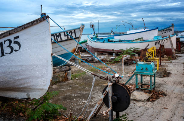 Pomorie town, Bulgaria - November 12, 2023:  Boats on the shore in Pomorie town, before the sunset. Burgas province, Bulgaria, Eastern Europe.