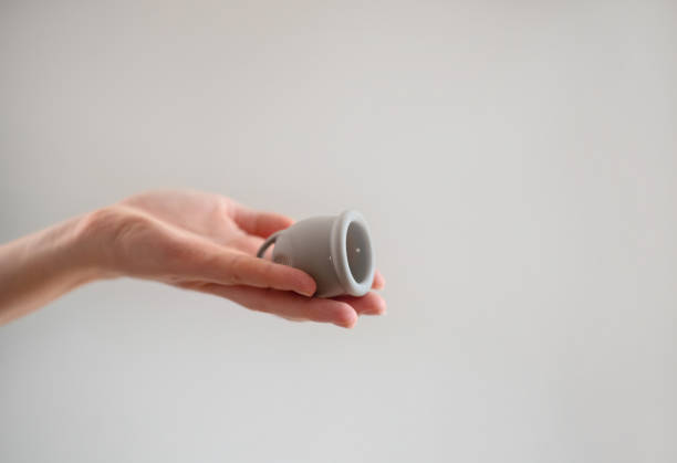 istock A woman's hand holds a reusable silicone menstrual cup, highlighting eco-friendly options for feminine hygiene. 2174358826