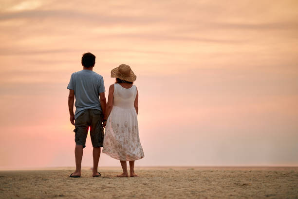 Senior couple enjoying sunrise on a beach vacation. Active seniors.