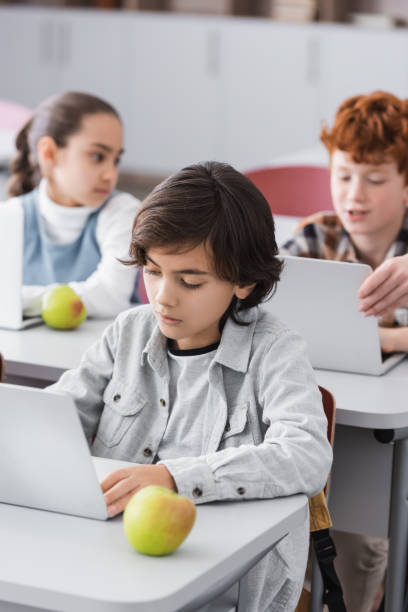 istock Schoolchildren work together on projects with laptops in a bright, modern classroom 2174361569