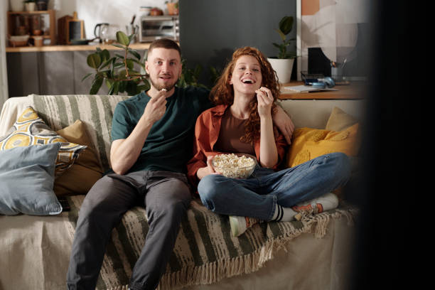 istock Young couple with popcorn watching movie 2174363910