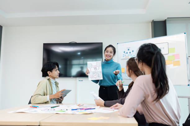 istock Team Collaborating on UX UI Design in Modern Office with Whiteboard and Digital Devices 2174365292