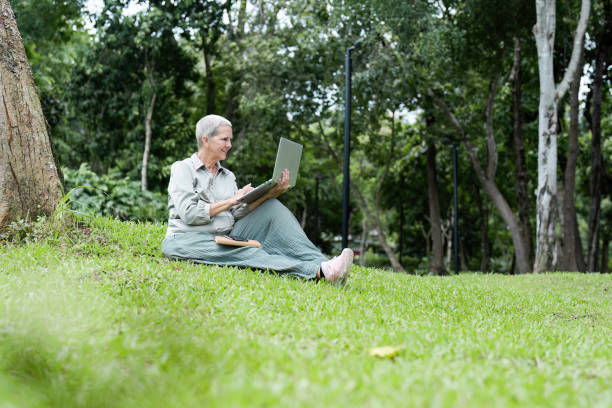 istock Senior Woman Reading a Book Outdoors in a Park on a Sunny Day 2174366275