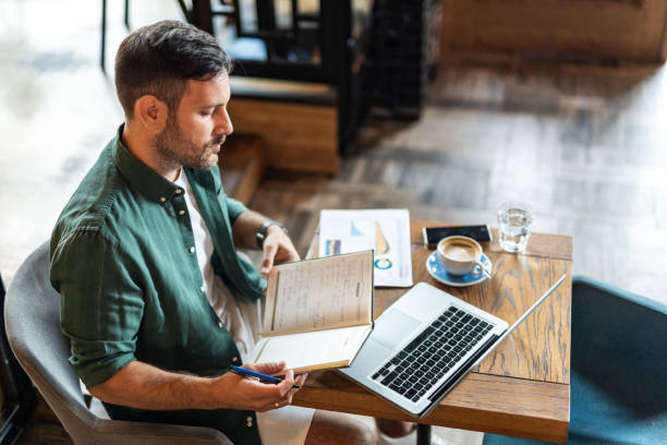 istock Balancing work and care: a man working in a cafe with a worried expression on his face 2174366343