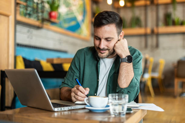 istock Balancing work and care: a man working in a cafe with a worried expression on his face 2174366437