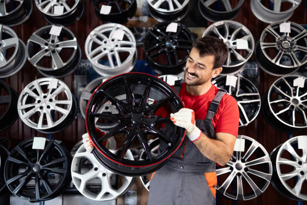 istock Tire technician holding aluminum car rims inside workshop. 2174366639