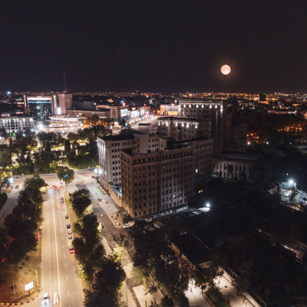 Aerial night scene with full moon above Freedom Square with Karazin University building view from Klochkivskyj Descent in Kharkiv city, Ukraine