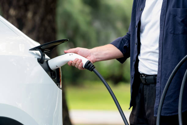 istock Man recharging battery for electric car during road trip. Exalt 2174372773