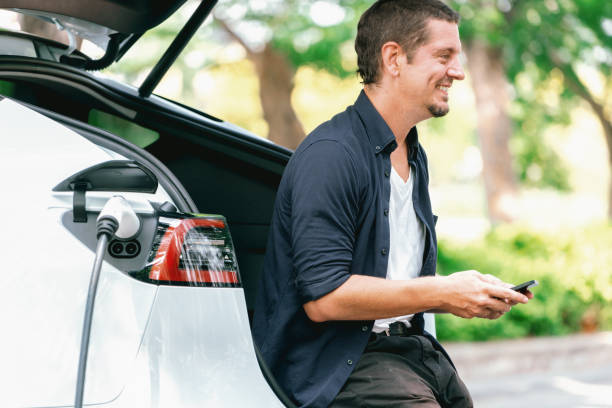istock Man using smartphone to pay for electric car charging. Exalt 2174373296