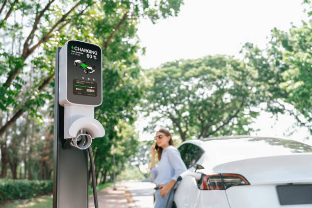 istock Young woman using smartphone to pay for electric car charging. Exalt 2174374980