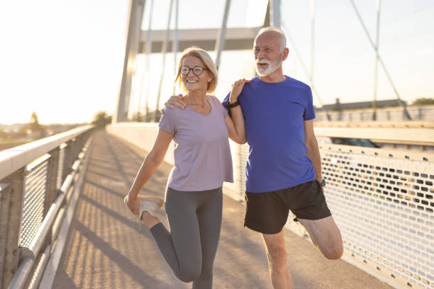 istock Senior couple stretches thighs during morning workout on bridge 2174376977