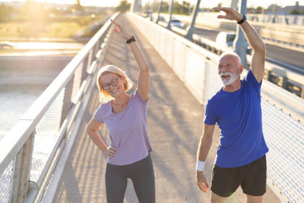 istock Elderly couple stretching arms up during their morning workout routine 2174376981