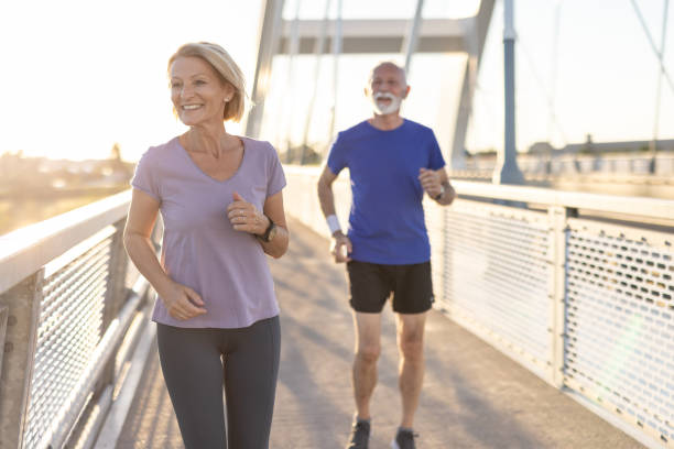 istock Elderly couple jogging on a bridge during a sunny morning run. 2174376991