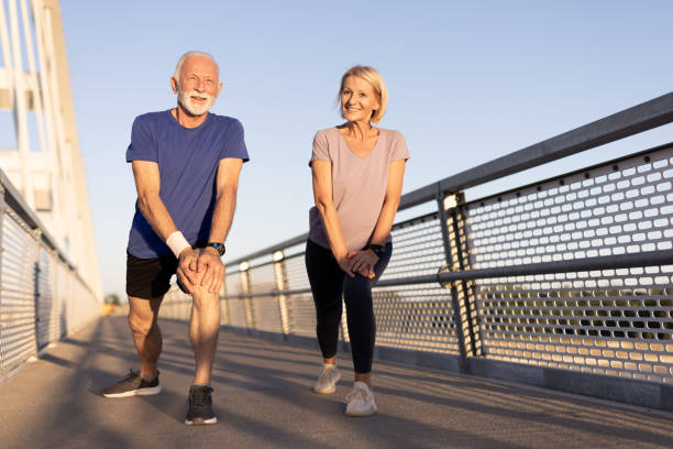 istock Elderly couple stretching on bridge during morning exercise 2174377074