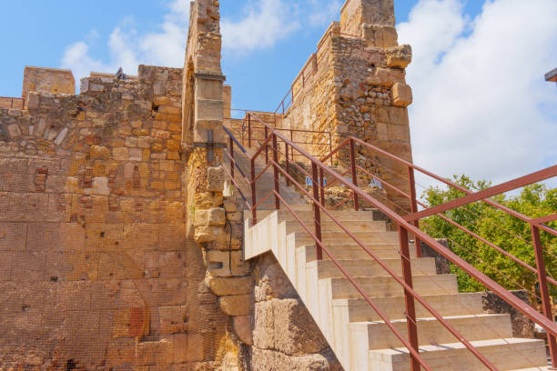 Stairs winding up alongside ancient stone structures in Tarragona.