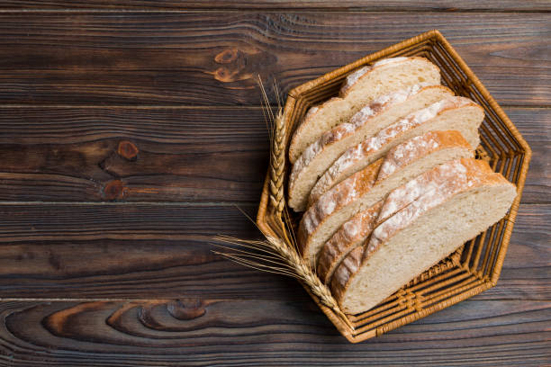 istock Freshly baked bread slices on basket against natural background. top view Sliced bread 2174378738