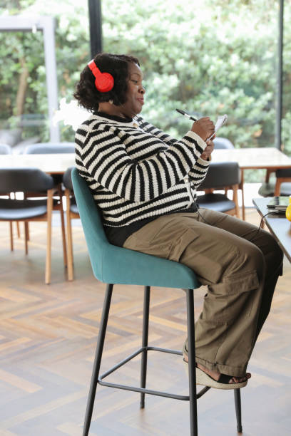 istock Woman wearing headphones and taking notes 2174382936