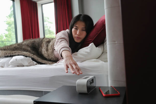 istock Woman reaching to turn off alarm clock 2174383383