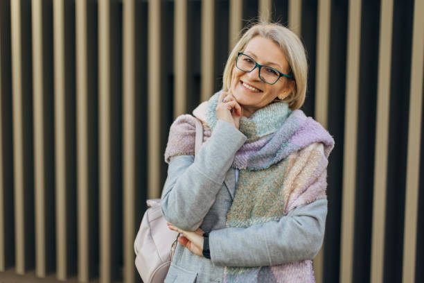 istock A smiling senior woman looking confident and satisfied, with a city environment backdrop 2174383430