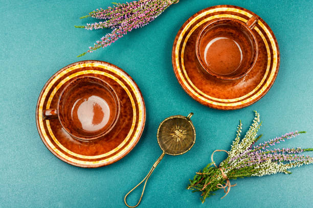 Fresh heather or Calluna vulgaris flowers with a cup of heather herbal tea. Herbal infusion. Flat lay