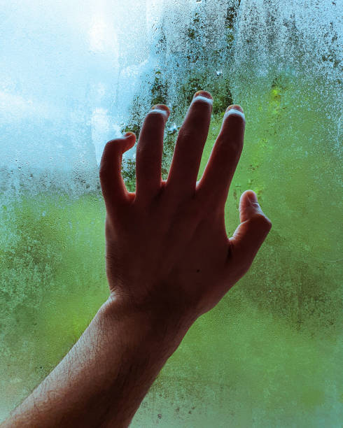 istock Bathroom window condensation with a hand and blurred background from outside 2174391200