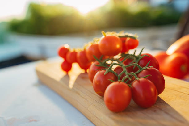 Close-up shot of a bunch of fresh organic cherry tomatoes on a wooden cutting board