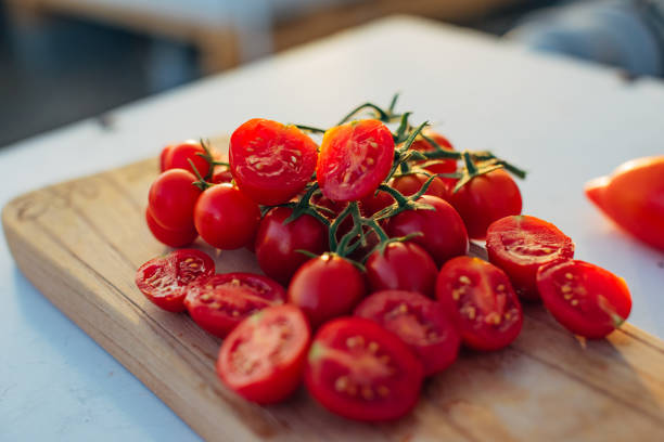 Close-up shot of a bunch of fresh organic cherry tomatoes on a wooden cutting board, no people