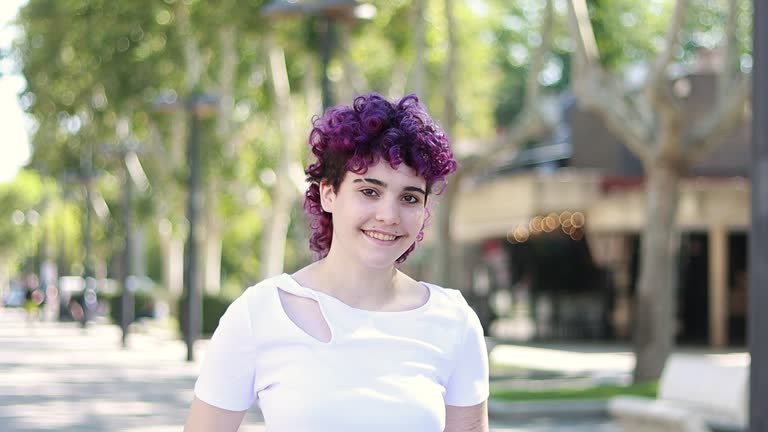 Video portrait of a woman with purple hair smiling
