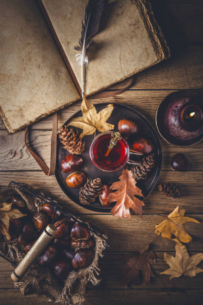 istock Fruit tea for cold autumn days, chestnuts  with autumn leaves and old book 2174398119