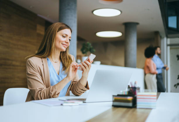istock Smiling businesswoman using a smartphone 2174402453