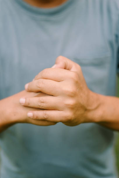 The left hand of a person is clenched into a fist, ready to undertake a challenging task, symbolizing strength and determination