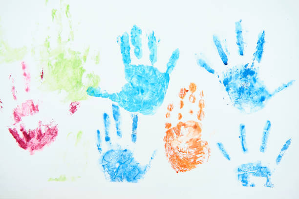 Bright children's handprints made with blue, green, red and orange paint on a white background.