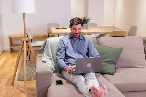 istock Young businessman working from home sitting on couch using laptop computer 2174408208
