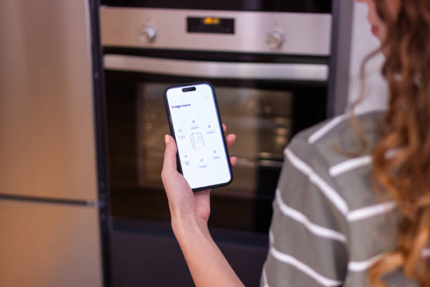istock Woman using smart home application controlling smart refrigerator with smartphone 2174411214